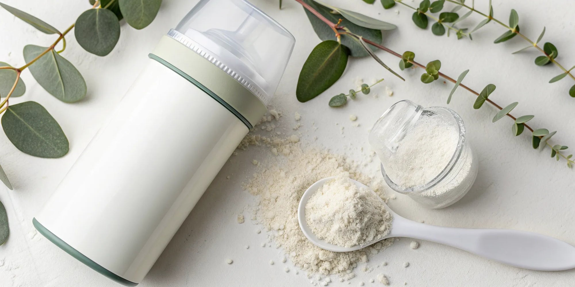 A can of dairy-free formula for infants with a scoop of powder and a baby bottle.
