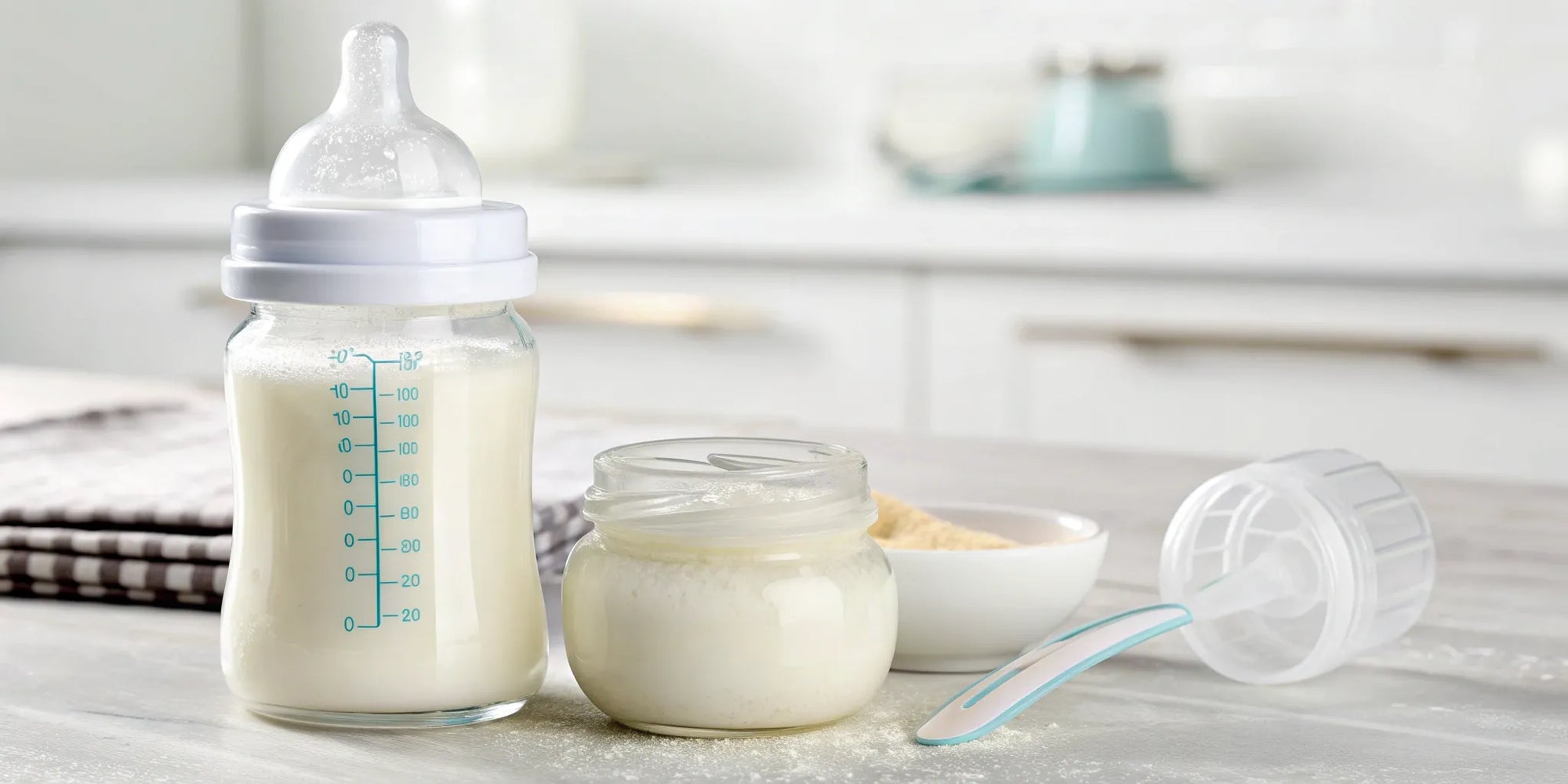 A bottle of infant formula for eczema next to a can of powder and a scoop.