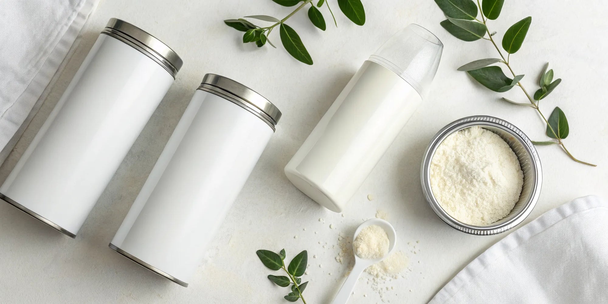 Cans of non-GMO baby formula with a scoop and a prepared baby bottle.