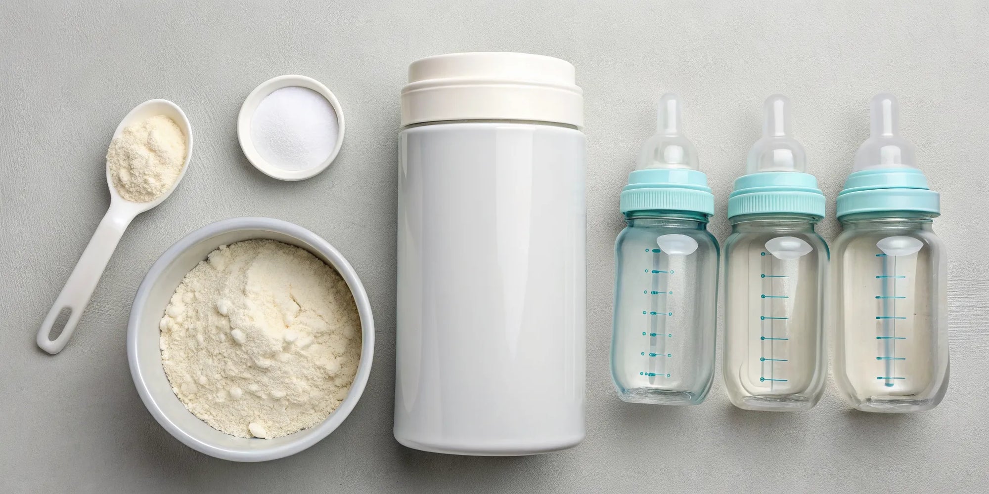 A baby formula starter kit with powdered formula, bottles, and a scoop.