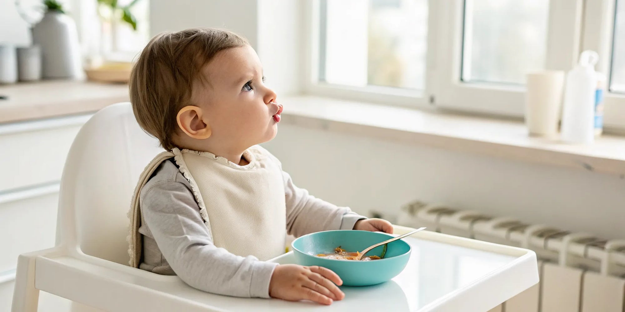 A toddler rejects the taste of new food while sitting in a high chair.